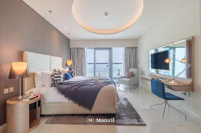 a bedroom with a bed and a desk and a television at Premium 2BR Apartment in Paramount Tower with City Skyline Views in Dubai