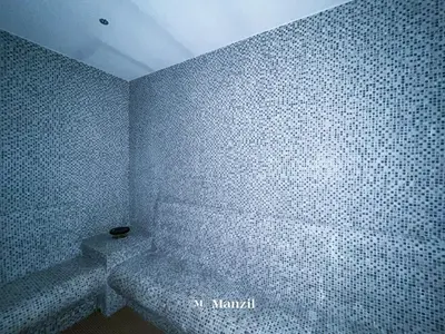 a bathroom with a white tiled wall at Premium 2BR Apartment in Paramount Tower with City Skyline Views in Dubai