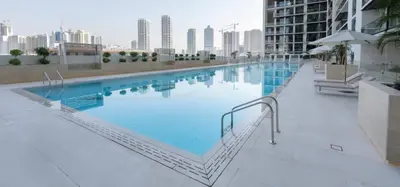 a large swimming pool on top of a building at Modern 1br W Calm Interiors Jvc Dubai in Dubai