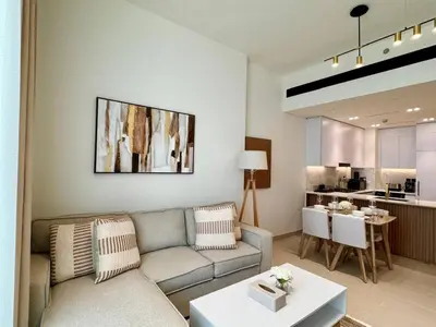 a living room with a couch and a table at Modern 1br W Calm Interiors Jvc Dubai in Dubai
