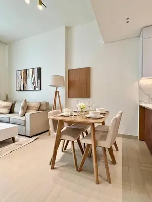 a living room with a table and chairs and a couch at Modern 1br W Calm Interiors Jvc Dubai in Dubai