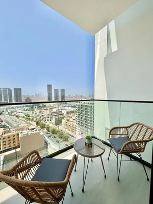 a balcony with two chairs and a table and a view at Modern 1br W Calm Interiors Jvc Dubai in Dubai