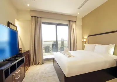 a hotel room with a bed and a large window at Elite Downtown Stay with Gym, Pool near Dubai Mall in Dubai