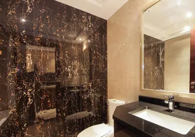a bathroom with a toilet and a black wall at Elite Downtown Stay with Gym, Pool near Dubai Mall in Dubai