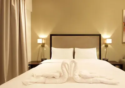 a bedroom with a bed with two white towels on it at Elite Downtown Stay with Gym, Pool near Dubai Mall in Dubai