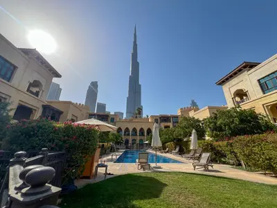 a courtyard with a swimming pool and a tall building at Durrani Homes - Luxe Living at Souk Al Bahar with Burj Khalifa and partial Fountain view in Dubai