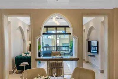 a living room with an archway and a dining room at Durrani Homes - Luxe Living at Souk Al Bahar with Burj Khalifa and partial Fountain view in Dubai