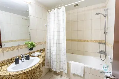 a bathroom with a sink and a shower and a tub at 1BR Cool Vibes Pool Views Dubai Marina in Dubai