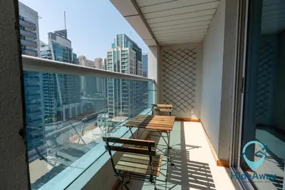 two chairs on a balcony with a view of a city at 1BR Cozy and Bright Dubai Marina in Dubai