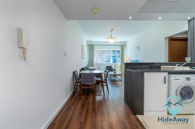 a kitchen with a washing machine and a dining room at 1BR Cozy and Bright Dubai Marina in Dubai