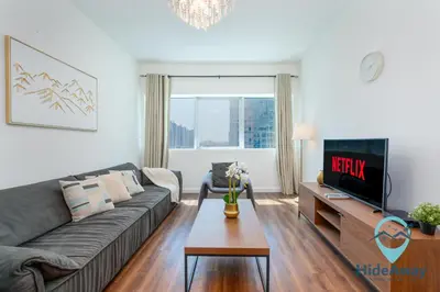 a living room with a couch and a tv at 1BR Cozy and Bright Dubai Marina in Dubai