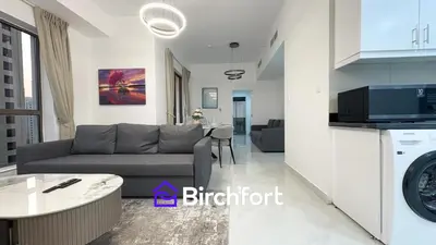 a living room with a couch and a kitchen at Spacious and Bright Retreat in JBR in Dubai