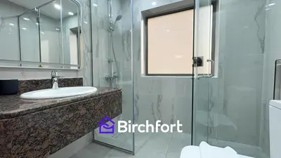 a bathroom with a sink and a glass shower at Spacious and Bright Retreat in JBR in Dubai