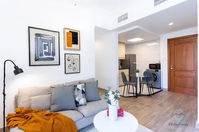 a living room with a couch and a table at 1BR Marina View Rooftop Pool Dubai Marina in Dubai