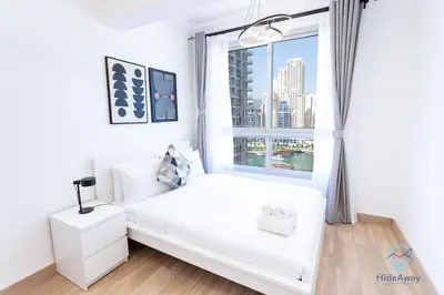 a bedroom with a white bed and a window at 1BR Marina View Rooftop Pool Dubai Marina in Dubai