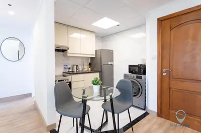 a kitchen with a glass table and chairs in a room at 1BR Marina View Rooftop Pool Dubai Marina in Dubai