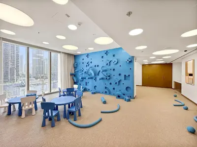 a conference room with tables and chairs and a blue wall at VayK - Luxury 1BR in Downtown in Dubai