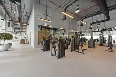 a gym with rows of exercise equipment and potted plants at VayK - Luxury 1BR in Downtown in Dubai
