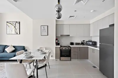 a kitchen and living room with a table and a couch at VayK - Luxury 1BR in Downtown in Dubai