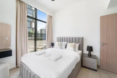 a white bedroom with a large bed and a window at VayK - Modern 3BR with a Spacious Terrace in Dubai