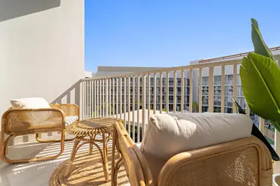 a balcony with chairs and a couch and a table at VayK - Stylish & Cozy Studio in JVC in Dubai