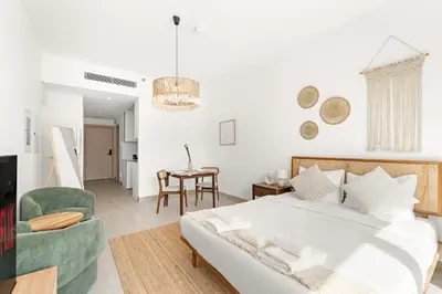 a bedroom with a bed and a living room at VayK - Stylish & Cozy Studio in JVC in Dubai