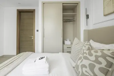 a white bed with white sheets and pillows at New 2BR with Pool and Gym in Green Sobha Community in Dubai