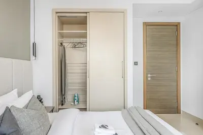 a bedroom with a bed and a closet at New 2BR with Pool and Gym in Green Sobha Community in Dubai