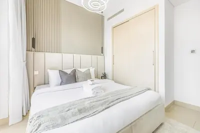 a bedroom with a large white bed with a large window at New 2BR with Pool and Gym in Green Sobha Community in Dubai