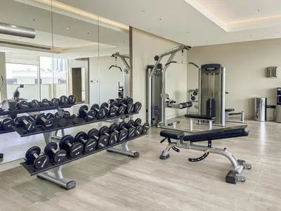 a gym with a lot of treadmills and mirrors at New 2BR with Pool and Gym in Green Sobha Community in Dubai