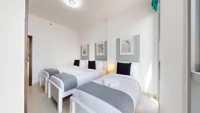 three beds in a room with white walls at Vacationer I Exclusive 2 Bedroom I Breathtaking Skyline & City Views I Afnan 1 - IMPZ in Dubai