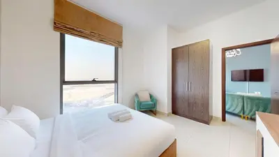 a white bedroom with a bed and a window at Vacationer I Exclusive 2 Bedroom I Breathtaking Skyline & City Views I Afnan 1 - IMPZ in Dubai