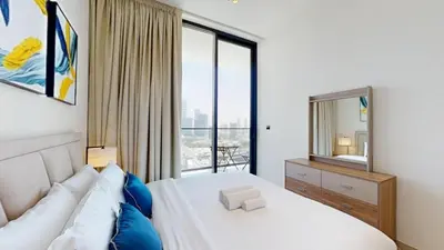 a bedroom with a bed and a large window at Binghatti Onyx - Two Bedroom with Private Pool in Dubai
