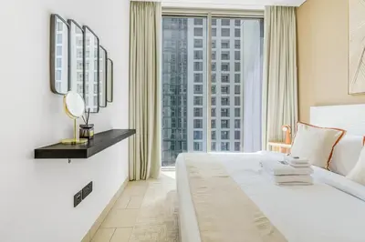 a bedroom with a large bed and a large window at Stylish 1BR with Pool, BBQ Area, Gym in MBR City in Dubai