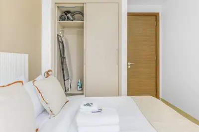 a bedroom with a white bed and a closet at Stylish 1BR with Pool, BBQ Area, Gym in MBR City in Dubai