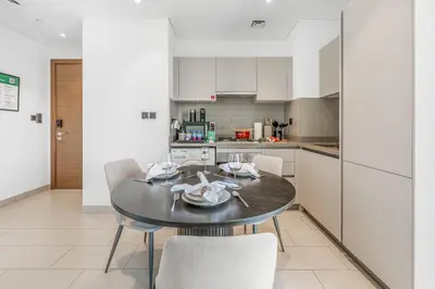 a kitchen and dining room with a table and chairs at Stylish 1BR with Pool, BBQ Area, Gym in MBR City in Dubai