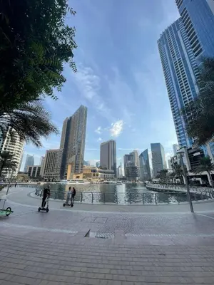 two people riding skateboards on a sidewalk in a city at Horizon JBR in Dubai