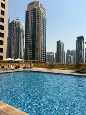 a large swimming pool in front of a city skyline at Horizon JBR in Dubai