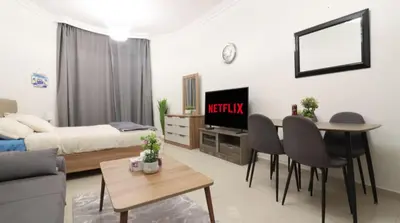 a living room with a bed and a table and chairs at Elegant Studio Near Burj Khalifa Pool and Gym in Dubai