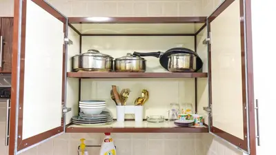 a kitchen cabinet with pots and pans and dishes at Elegant Studio Near Burj Khalifa Pool and Gym in Dubai