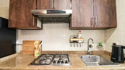 a kitchen counter with a stove and a sink at Elegant Studio Near Burj Khalifa Pool and Gym in Dubai