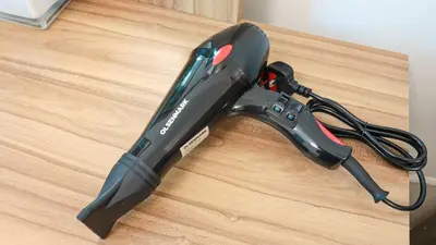 a black cordless drill sitting on top of a wooden table at Elegant Studio Near Burj Khalifa Pool and Gym in Dubai