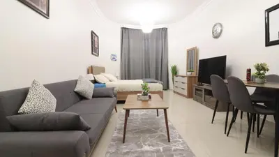 a living room with a couch and a table at Elegant Studio Near Burj Khalifa Pool and Gym in Dubai
