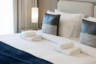 a white bed with towels on top of it at Burj & Fountain View 5-Min Walk to Dubai Mall in Dubai