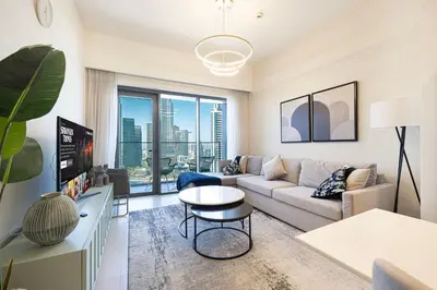 a living room with a couch and a table at Burj & Fountain View 5-Min Walk to Dubai Mall in Dubai