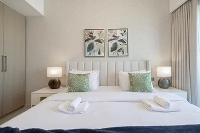 a bedroom with a large white bed with two towels at Burj & Fountain View 5-Min Walk to Dubai Mall in Dubai