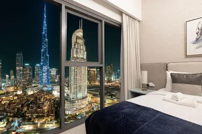 a bedroom with a large window with a view of a city at Burj & Fountain View 5-Min Walk to Dubai Mall in Dubai