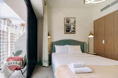 a bedroom with a bed and a large window at Stylish studio in Azizi 42 in Dubai