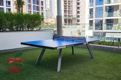 a ping pong table sitting on top of grass at Stylish studio in Azizi 42 in Dubai
