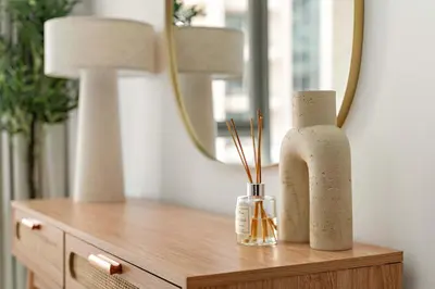 a wooden table with two vases and a mirror at Silkhaus Elite 1BDR at 29 Boulevard Downtown in Dubai